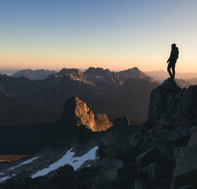 A person looking over amazing mountains and a sunset
